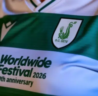 Close-up of a green and white striped soccer jersey with the sponsor text 'Worldwide Festival 2026, 20th anniversary' and a crest on the chest.