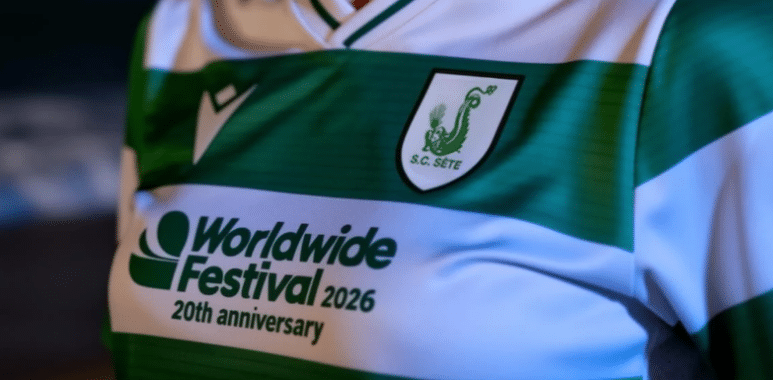 Close-up of a green and white striped soccer jersey with the sponsor text 'Worldwide Festival 2026, 20th anniversary' and a crest on the chest.