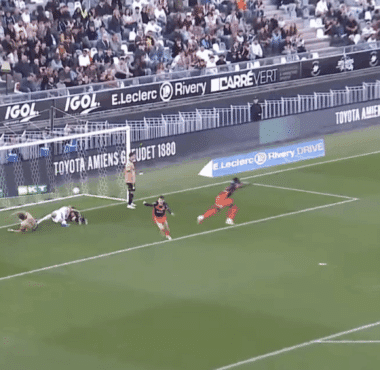 Soccer scene near goal: players in tan and red uniforms around the net as a ball sits by the goalkeeper on the ground, crowd in stands behind. BeIN SPORTS watermark visible.