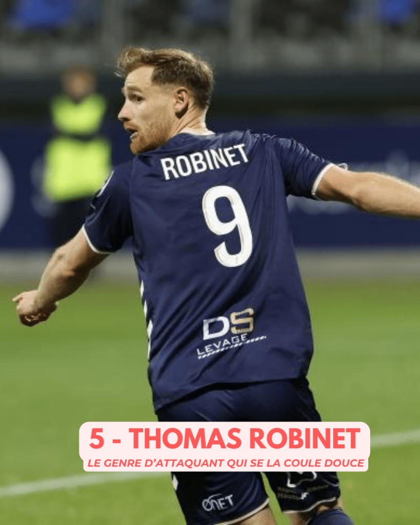 Soccer player Thomas Robinet seen from behind in a navy jersey with number 9, mid-action on the field.
