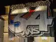 Nighttime street view: a large white banner with bold black outline '34' and colorful red/blue accents covering a building fa&ccedil;ade.