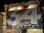 Nighttime street view: a large white banner with bold black outline '34' and colorful red/blue accents covering a building fa&ccedil;ade.