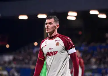 Jean Ruiz | AllezPaillade.com Male soccer player in a white and maroon jersey on the field, looking focused during a match.