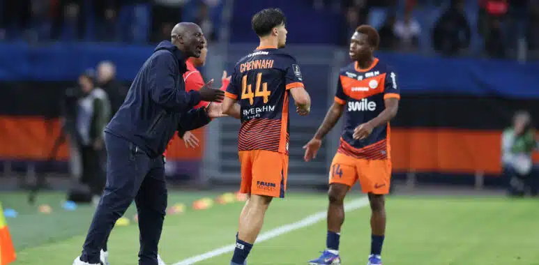Montpellier Herault SC v Clermont Foot 63 - Ligue 2 BKT 20252026 | AllezPaillade.com Soccer coach and players on a field during a match, one player wearing number 44 greeted by the coach at sideline before restart.