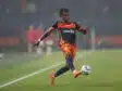 Tchato Montpellier Herault SC v Clermont Foot 63 - Ligue 2 BKT 20252026 | AllezPaillade.com Soccer player in navy and orange kit handling a ball on a grass field during a match and focused on action to the right.
