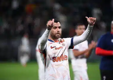 Teji SAVANIER of - Photo by Icon Sport | AllezPaillade.com Soccer player in a white jersey with orange pattern, giving two thumbs up on the field.