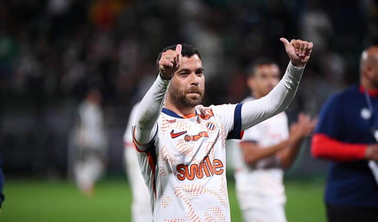 Teji SAVANIER of - Photo by Icon Sport | AllezPaillade.com Soccer player in a white jersey with orange pattern, giving two thumbs up on the field.