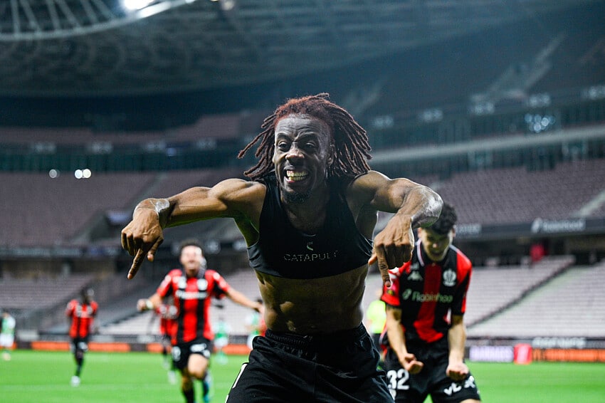 Elie Wahi | AllezPaillade.com Soccer player with dreadlocks celebrates toward the camera on a stadium field, arms outstretched and smiling.