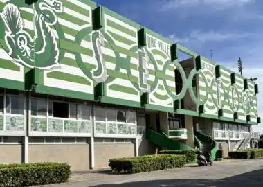 719782558_1590845809717930_2617558429739301231_n | AllezPaillade.com Green and white stadium façade with large stylized letters and arches along the front.