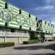 Green and white stadium fa&ccedil;ade with large stylized letters and arches along the front.
