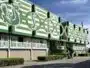 Green and white stadium fa&ccedil;ade with large stylized letters and arches along the front.