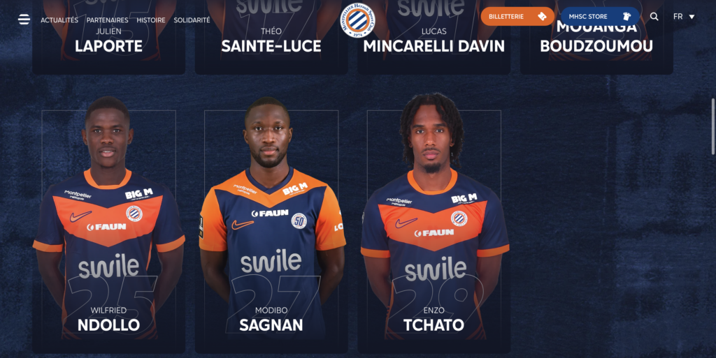 Three male football players in orange and navy jerseys stand side by side on a dark blue backdrop, with numbers 25, 27, 28 and names Ndollo, Sagnan, Tchato.