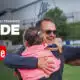 A man hugging a young girl and a female footballer on a grassy field, with YouTube and 'INSIDE' branding in white text above, suggesting a video feature.