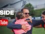 A man hugging a young girl and a female footballer on a grassy field, with YouTube and 'INSIDE' branding in white text above, suggesting a video feature.