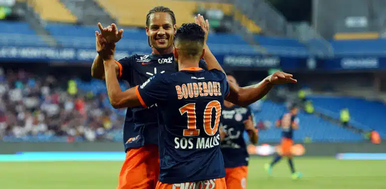 Congré | AllezPaillade.com Boudebouz #10 celebrating with a teammate on the soccer field in blue and orange kit.
