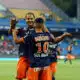 Boudebouz #10 celebrating with a teammate on the soccer field in blue and orange kit.
