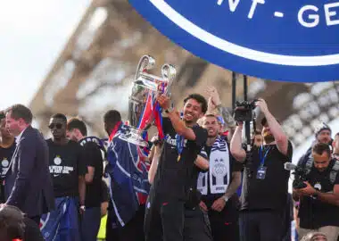 Paris Saint-Germain - UEFA Champions League 20252026 - Celebrations and Trophy Presentation - Champs de Mars 31052026 | AllezPaillade.com Athlete lifts a silver trophy amid cheering teammates during a victory celebration in a stadium.