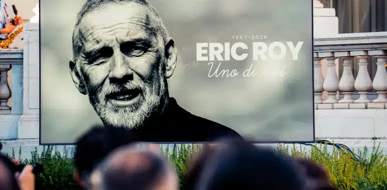 Large outdoor billboard featuring a black-and-white portrait of Eric Roy, with the text '1967-2026 ERIC ROY Uno di moi' on a gray background.