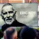Large outdoor billboard featuring a black-and-white portrait of Eric Roy, with the text '1967-2026 ERIC ROY Uno di moi' on a gray background.