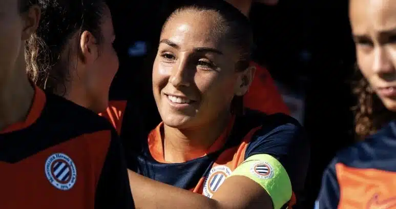 Screenshot | AllezPaillade.com Women’s soccer team celebrates, central player smiles while teammates hug.