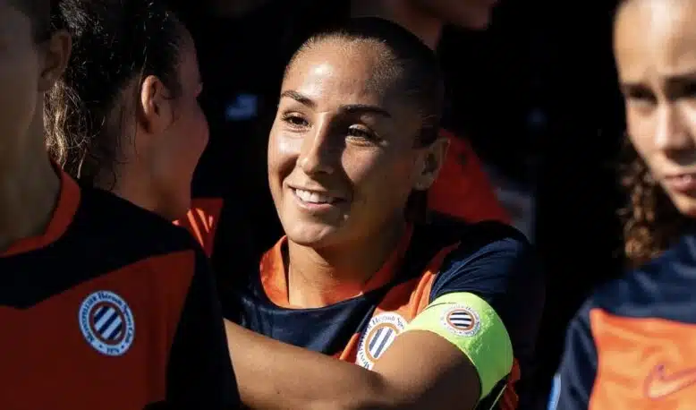 Screenshot | AllezPaillade.com Women’s soccer team celebrates, central player smiles while teammates hug.