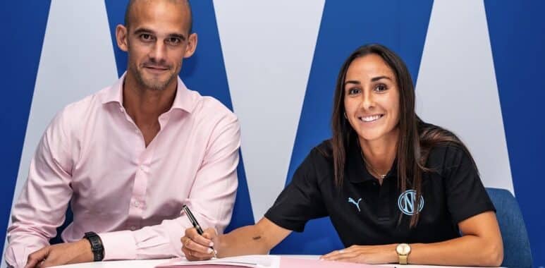 Screenshot | AllezPaillade.com Two professionals signing documents at a white table; man in a pink shirt, woman in black polo, blue backdrop.
