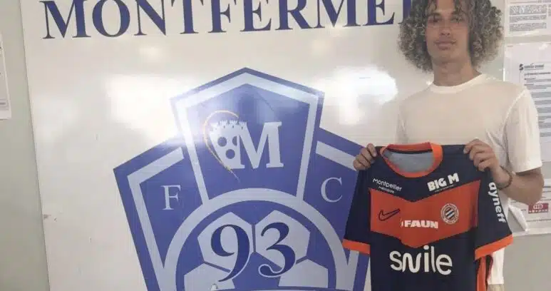 Screenshot | AllezPaillade.com Young man with curly hair posing beside a large Football Club Montfermeil sign, holding a navy and orange Montfermeil football jersey.