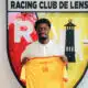 Young man in a white polo holds up a bright yellow jersey in front of the Racing Club de Lens crest.