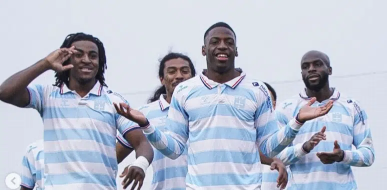 Capture décran 2026-07-11 à 214545 | AllezPaillade.com Five male athletes in light blue and white striped jerseys pose together and smile on a sports field, signaling victory.