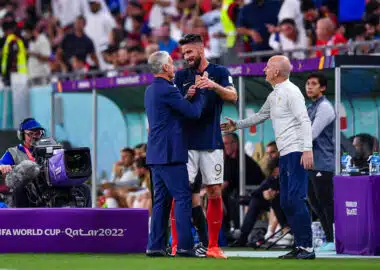 France v Poland - FIFA World Cup 2022 Round of 16 | AllezPaillade.com Soccer players shake hands on the sideline during a FIFA World Cup match (Qatar 2022), with a cameraman filming nearby.