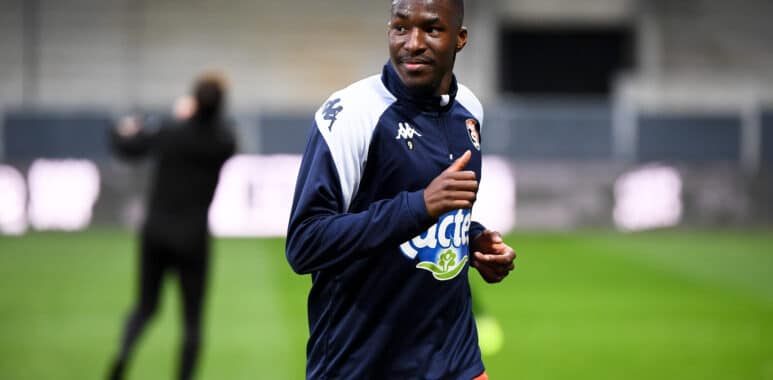 Mamadou Camara Red Star FC v Stade Lavallois Mayenne FC - Ligue 2 BKT 20252026 | AllezPaillade.com Male soccer player in navy and white jacket running on a green field during training, with blurred background.