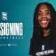Smiling woman with dreadlocks in a navy shirt against a teal background, large 'NEW SIGNING' text and team logos nearby.