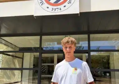 Screenshot | AllezPaillade.com Young man stands outside Montpellier Hérault Sport Club, holding a red-and-navy team jersey in front of the storefront sign.