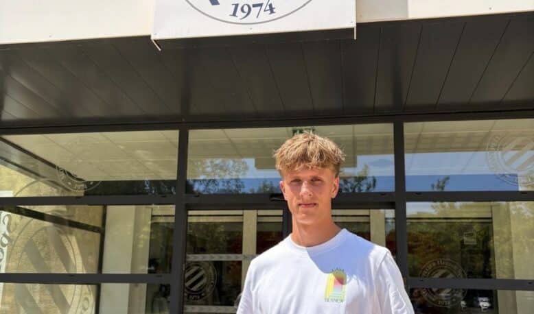 Screenshot | AllezPaillade.com Young man stands outside Montpellier Hérault Sport Club, holding a red-and-navy team jersey in front of the storefront sign.