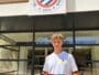 Young man stands outside Montpellier H&eacute;rault Sport Club, holding a red-and-navy team jersey in front of the storefront sign.