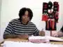 Person signing documents at a table with a Flamengo jersey and scarves displayed in the background, suggesting a contract signing.