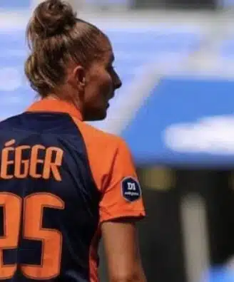 Soccer player seen from behind wearing an orange and navy jersey with the name L&Eacute;GER and number 25 on the back, in a stadium.