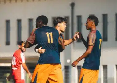 Prépa | AllezPaillade.com Two soccer players celebrate together on the field, wearing blue jerseys and orange shorts, with the number 11 on one player's back.