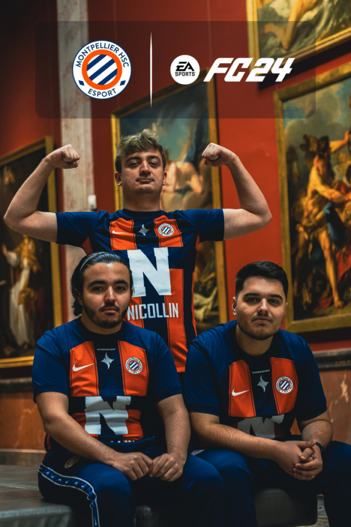 design_sans_titre_1_003 | AllezPaillade.com Three esports players from Montpelier HSC Esport pose in matching blue-and-orange jerseys in a museum gallery, one standing and flexing his arms while two sit at the front. The FC24 and EA Sports logos appear above them.