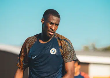 image | AllezPaillade.com Male soccer player in a dark blue training jersey on a sunny day, focused during practice.