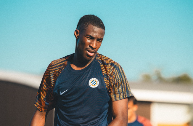 image | AllezPaillade.com Male soccer player in a dark blue training jersey on a sunny day, focused during practice.