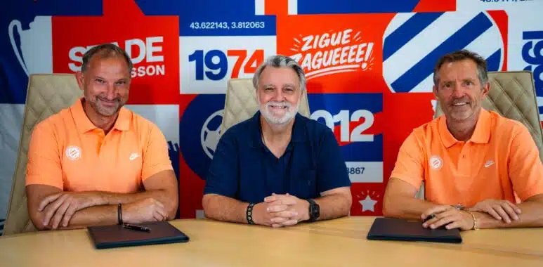 nicollin lefèvre maraval | AllezPaillade.com Three men sit at a table in front of a bright, graphic backdrop; left and right wear orange polo shirts while the center wears a dark blue shirt, posing for a team photo in front of a sports-club banner.