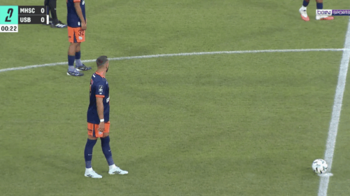 Soccer players in blue and orange uniforms stand near the center line; ball sits on the field as a 0-0 scoreboard and timer appear on screen (00:22) with a beIN SPORTS logo.