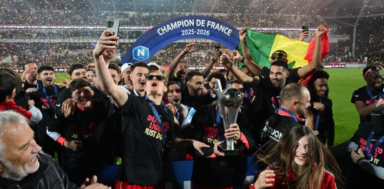 Dijon FCO v Orleans US 45 - National 1 20252026 | AllezPaillade.com Celebrating football team holding a trophy beneath a blue 'Champion de France 2025-2026' arch amid confetti.