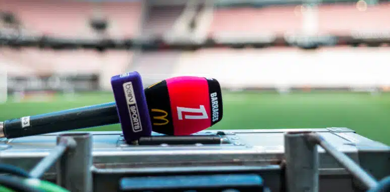 OGC Nice v AS Saint-Etienne - Ligue 1 McDonalds 20252026 - RelegationPromotion Playoffs | AllezPaillade.com Close-up of a red and purple sports microphone resting on a control desk with blurred stadium seating in the background.
