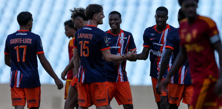 Laporte Mamadou Camara Montpellier Herault SC v Rodez Aveyron Football - Friendly Match 01082026 | AllezPaillade.com Group of young soccer players in blue and orange jerseys greet each other with handshakes and smiles on a grassy field.