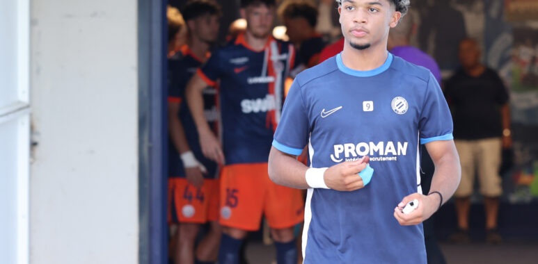 Montpellier Herault SC v Rodez Aveyron Football - Friendly Match 01082026 | AllezPaillade.com Young male soccer player in blue jersey stepping out of the tunnel, teammates in orange uniforms behind him.