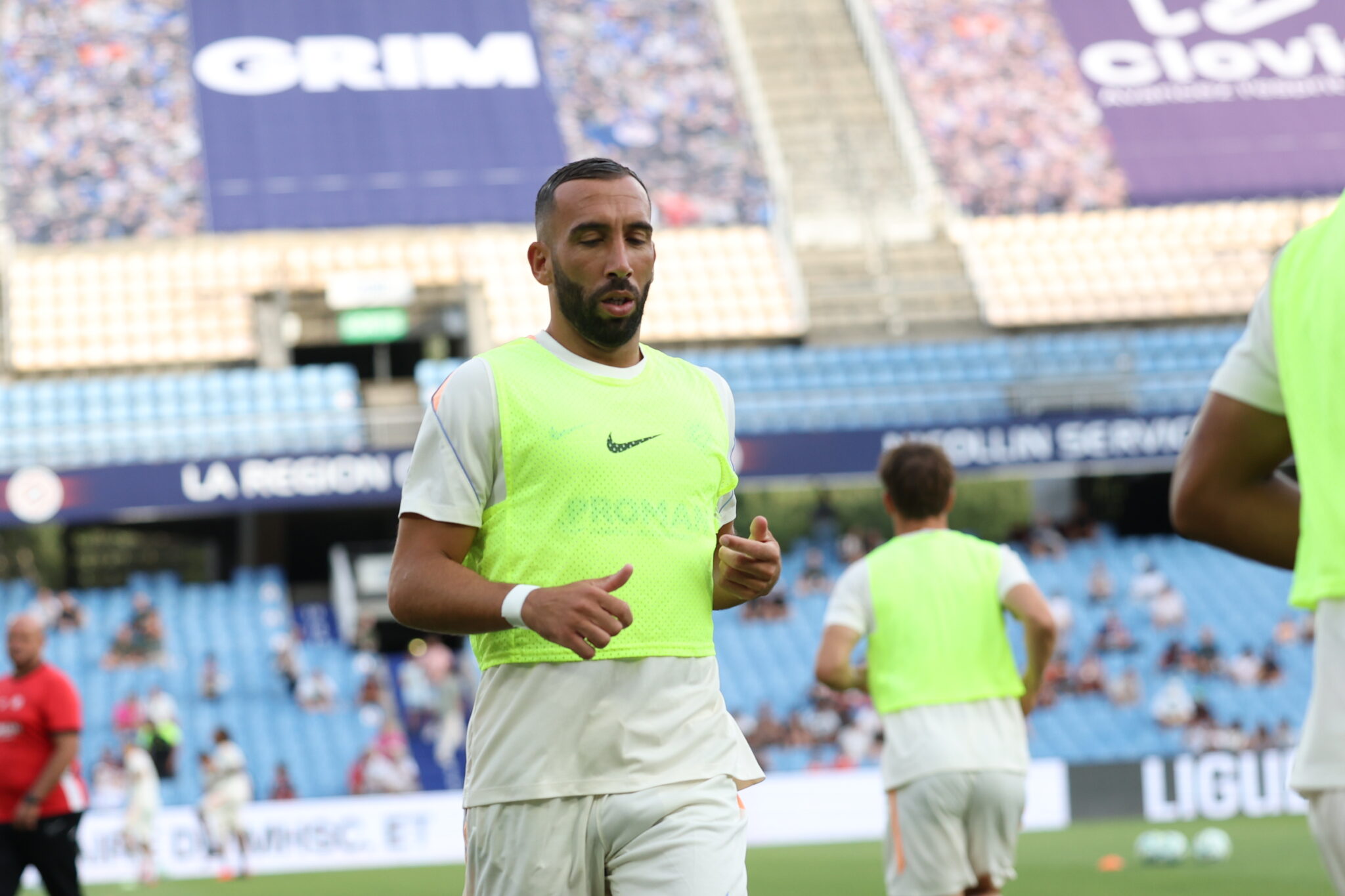 Florian TARDIEU Photo by Icon Sport - Photo by Icon Sport | AllezPaillade.com Soccer player in a neon training bib running on the pitch with blurred stadium stands in the background