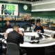 Five men in a podcast studio around a circular table with microphones and laptops, a night city backdrop and an 'AFTER FOOT' sign.