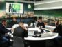 Five men in a podcast studio around a circular table with microphones and laptops, a night city backdrop and an 'AFTER FOOT' sign.